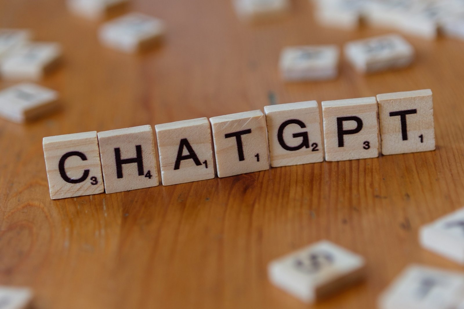 Scrabble tiles spelling ChatGPT on a wooden table